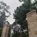 Un edificio di cui sono rimasti il muro perimetrale in pietra e il cancello di ingresso racchiuso da due colonne...